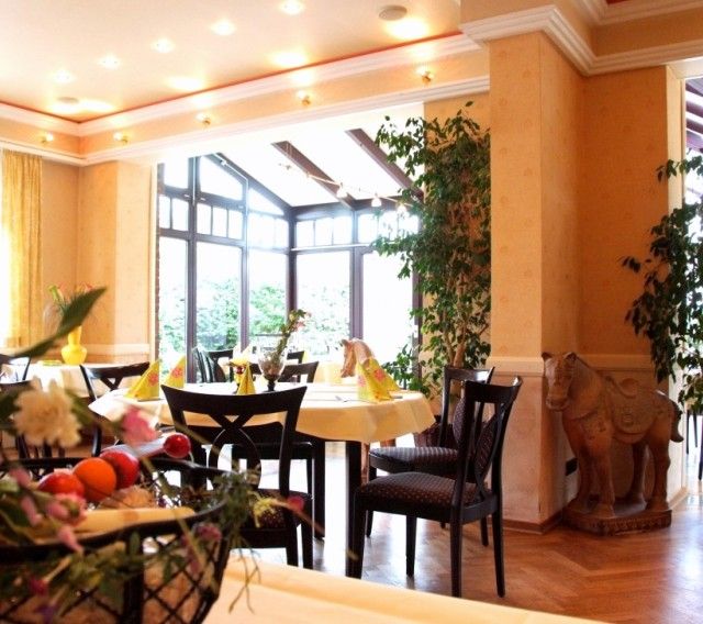 einladendes Restaurant mit gelben Wänden und runden Tischen mit gelben Tischdecken und Servietten